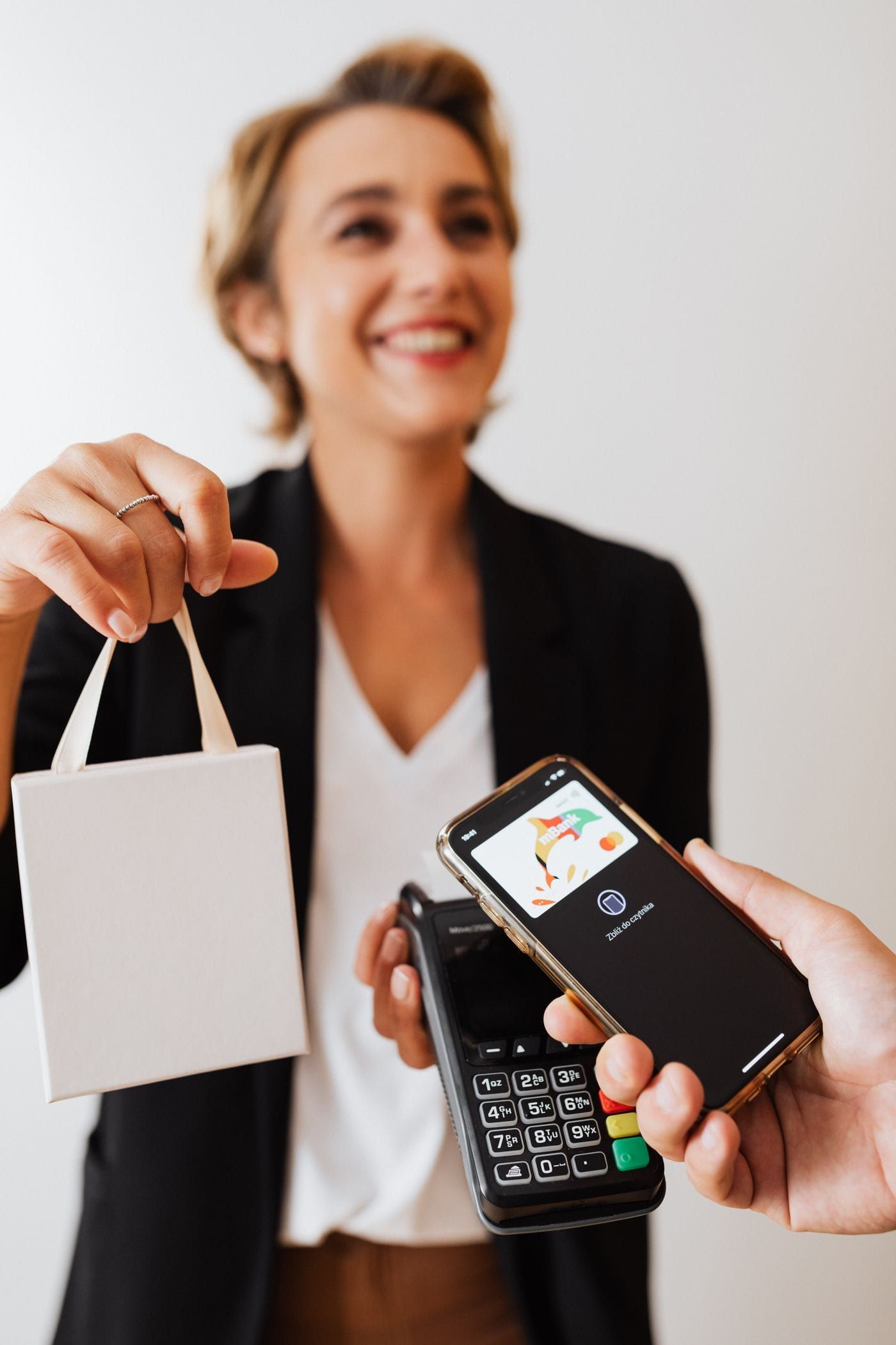 Una clienta paga con el celular en el datáfono de una tienda